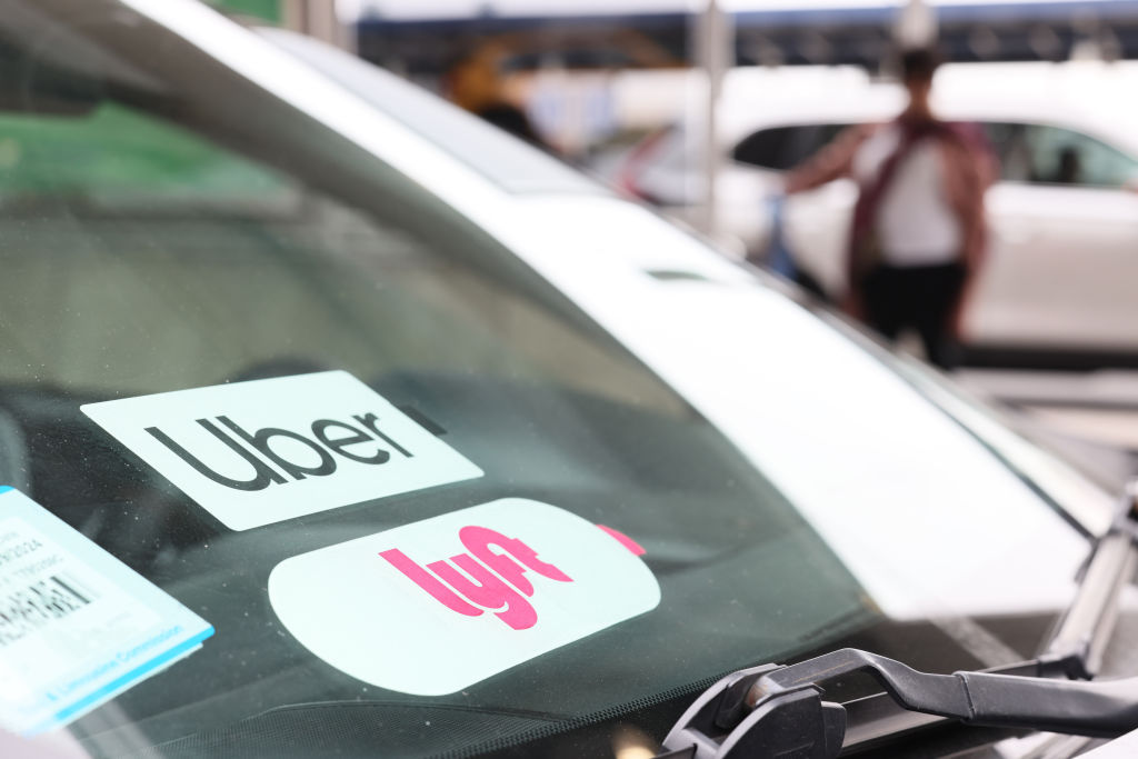 NEW YORK, NEW YORK - APRIL 28: A Lyft decal is seen on a car in the pick-up area at JFK Airport on April 28, 2023 in New York City. Lyft, the ride-hailing app, confirmed that it will be laying off 1,072 employees, which equals to roughly 26% of its corporate workforce. The layoffs were announced last week but no official number was confirmed. (Photo by Michael M. Santiago/Getty Images)