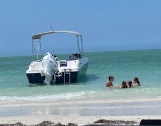 A boat anchored next to Three Rooker Island